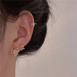 Detail shot of heart and star zircon earrings with ear cuff worn on the ear
