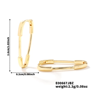 Macro shot of gold safety pin earrings with cubic zirconia detail and size dimensions