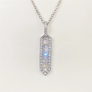Macro shot of silver baguette-cut pendant with halo setting on thin cable chain