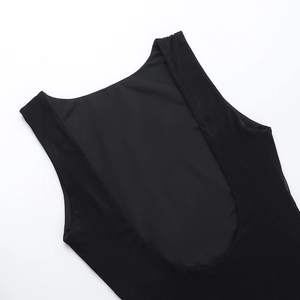 Detail of a black backless sleeveless dress featuring a deep U-neck and matte fabric texture