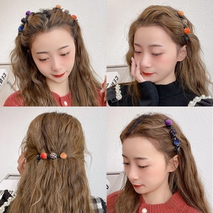 Detailed views of a black cross hair claw clip featuring colorful woven decorative balls