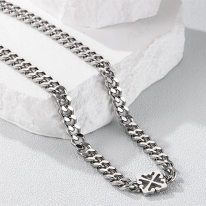 Detailed close-up of a silver titanium steel Cuban link necklace with a cross pendant