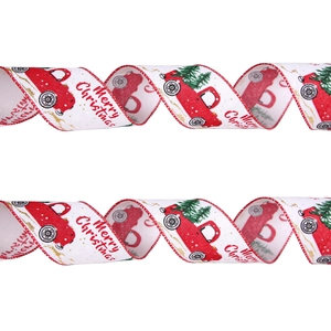 Detail of Christmas ribbon with red truck and Merry Christmas text on white fabric