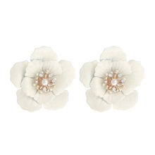 Detail of flower earrings with white petals and elegant pearl and gold center accents