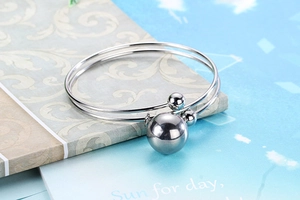 Detail shot of silver double-layer bracelet with polished spheres on textured background