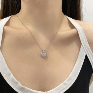 Close-up of heart and pear-shaped zircon pendant necklace worn on neck