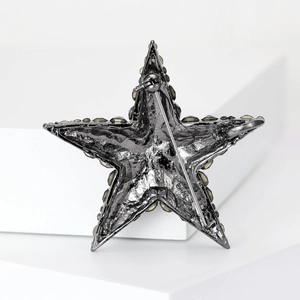 Detail of star-shaped brooch back showing gunmetal plating and secure pin closure