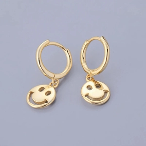 Detailed close-up of gold-plated hoop earrings with hollow smiley face pendants