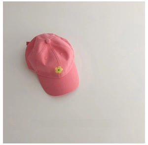 Détail de la casquette rose pour enfants avec broderie fleur jaune sur fond blanc