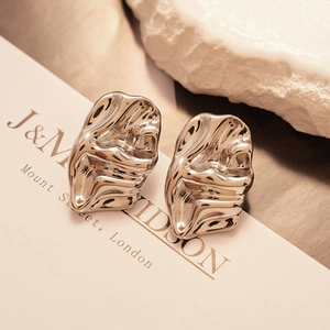 Macro shot of silver textured irregular earrings with high-polish metallic finish