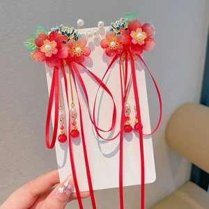 Detail of traditional Chinese hair clips with red flowers and long tassel ribbons