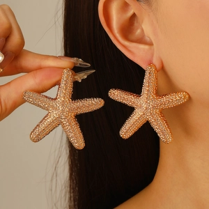 Statement oversized gold starfish stud earrings with textured finish for beach vacations