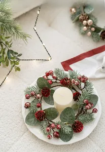 Detail von Weihnachtskerzenkranz mit roten Beeren, Zapfen und Eukalyptusblättern
