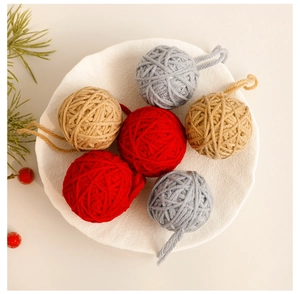 Close-up of knitted wool Christmas ball ornaments in red and grey with hemp ropes