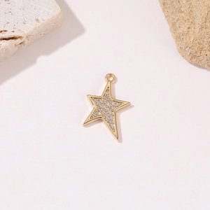 Close-up of a gold star pendant with clear zircon stones on textured stone props