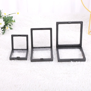 Three square black PE film jewelry floating display boxes in varying sizes on plush surface