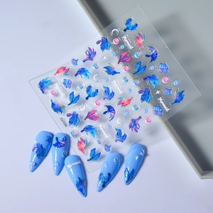 Detailed view of 3D mermaid tail nail art stickers with iridescent blue shells