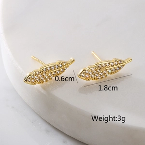 Elegant 18K gold plated feather earrings with micro-set zircons on marble stand