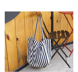 Detailed macro view of navy and white striped canvas tote bag on an outdoor chair