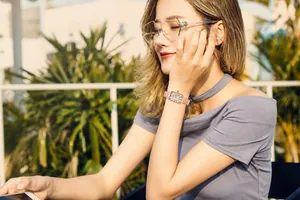 Primo piano dell'elegante orologio rettangolare in oro rosa con numeri romani e maglia