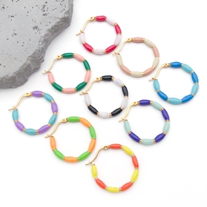 Detailed top view of various colorful bamboo-style enamel hoop earrings on white background