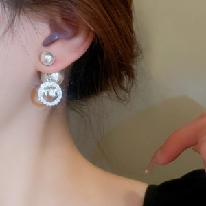 Elegant pearl and zircon letter drop earrings shown on model with high gloss finish