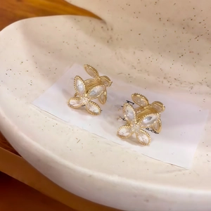 Gros plan de pinces à cheveux papillon dorées avec cristaux sur un plateau en coquillage