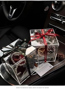 Close-up of Christmas acrylic gift box with apple and pearls inside a luxury car interior
