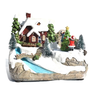 Détail d'une scène de Noël miniature avec maison enneigée, figurines et lumières LED