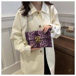 Detail of purple leopard print envelope clutch featuring a gold rectangular twist lock closure