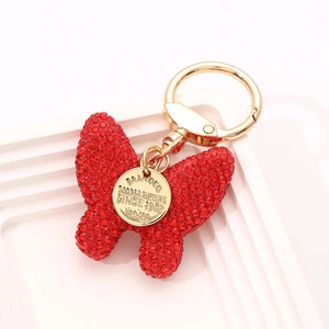 Red rhinestone butterfly keychain with golden metal ring and engraved brand tag