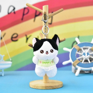 Detailed view of cute cat plush keychain with lace dress on a wooden display