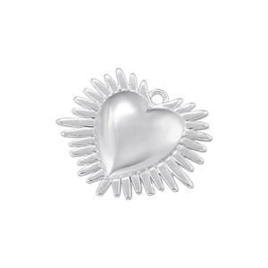 Macro shot of silver heart pendant with sunburst edge and polished metallic finish