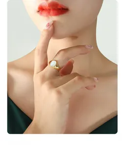 Détail d'une bague en titane plaqué or de style français avec incrustation en nacre blanche