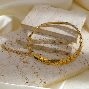 Macro detail of gold plated stainless steel snake chain bracelet on elegant stone