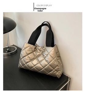 Détail du sac cabas matelassé champagne avec finition brillante et anses en tissu noir