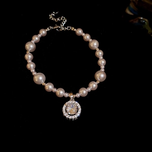 Close-up of pearl bracelet with central zircon pendant and adjustable lobster clasp