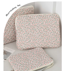 Détail de pochettes d'ordinateur à fleurs en coton avec rembourrage et fermetures éclair