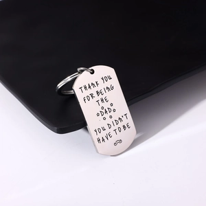 Macro detail of engraved stainless steel dog tag keychain with Thank You Dad message