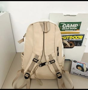 Detail view of the beige outdoor backpack showing ergonomic straps and anti-theft back pocket