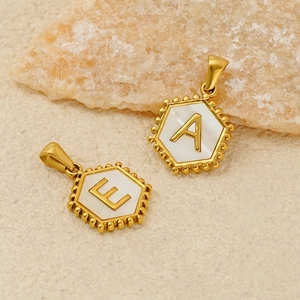 Macro shot of hexagonal 18K gold plated pendants with mother-of-pearl letters A and E