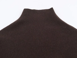 Dettaglio del collo a lupetto marrone che mostra la trama a maglia fine e il tessuto spesso