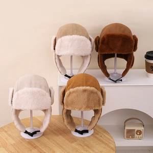 Détail de quatre chapeaux trappeur d'hiver en daim avec doublure pelucheuse et sangle réglable