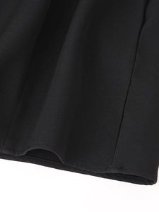 Close-up of the pleated hem and premium woven fabric texture on a black chiffon dress