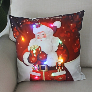 Detail of Christmas LED pillow with Santa and Nutcracker motif on beige sofa