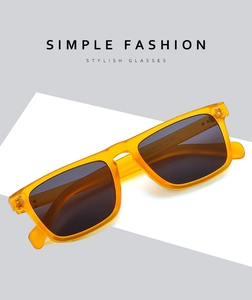 Detail view of stylish translucent orange square sunglasses with dark grey lenses