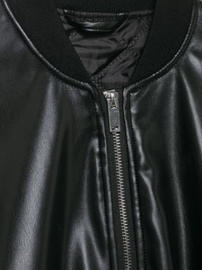 Detailed view of the ribbed knit collar and metal zipper on this black coated jacket