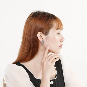 Elegant silver rose flower stud earrings shown on model with a clean white background