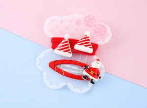 Detail view of festive Christmas hair clips and ties with Santa and hat motifs on display card