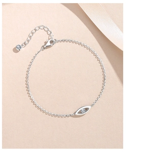 Detailed close-up of s925 silver Evil Eye bracelet with zircon inlay on silk background